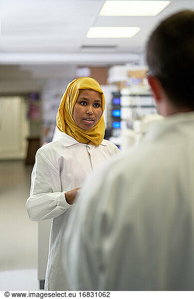 Weibliche Wissenschaftlerin im Hijab im Gespräch mit Kollegin im Labor