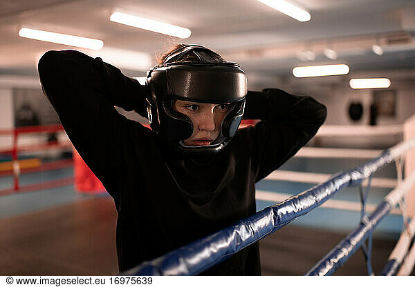 Weiblicher Boxer setzt vor dem Kampf einen Helm auf