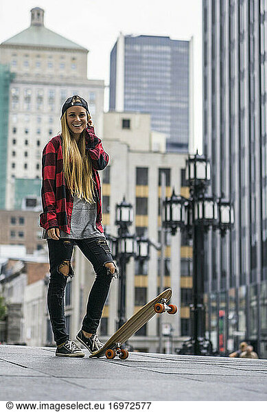 Weiblicher Millennial in städtischem Gebiet mit Skateboard bereit zu rollen ar
