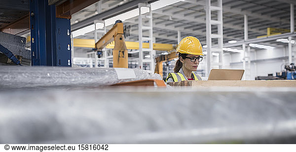 Weiblicher Vorgesetzter mit Laptop in einer Fabrik