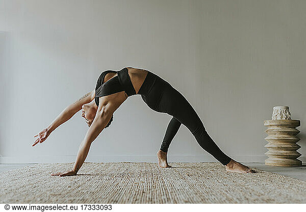Weiblicher Yogalehrer beugt sich beim Üben im Studio nach hinten