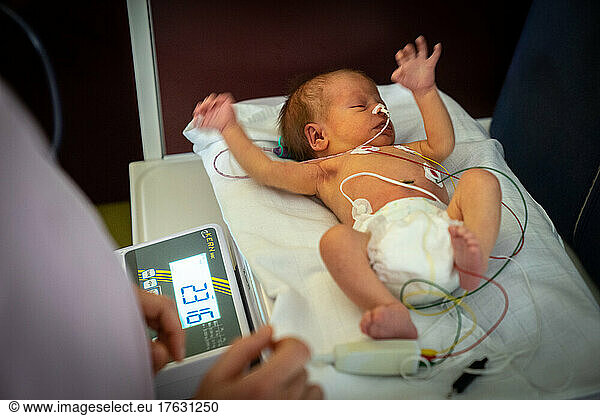 Weighing of a baby born prematurely by a midwife in a hospital center.