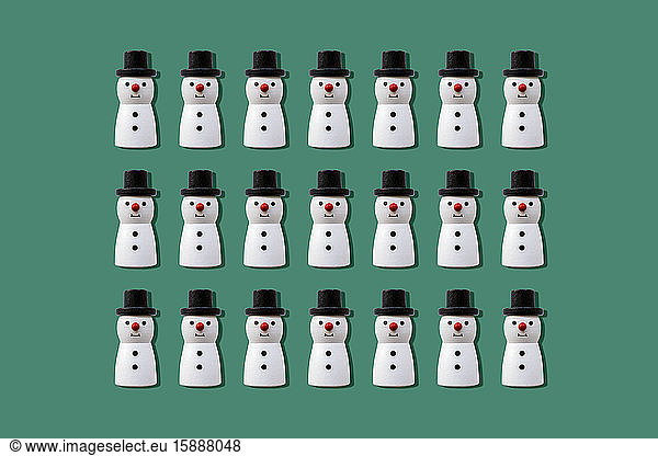 Weihnachts-Schneemänner-Muster vor grünem Hintergrund