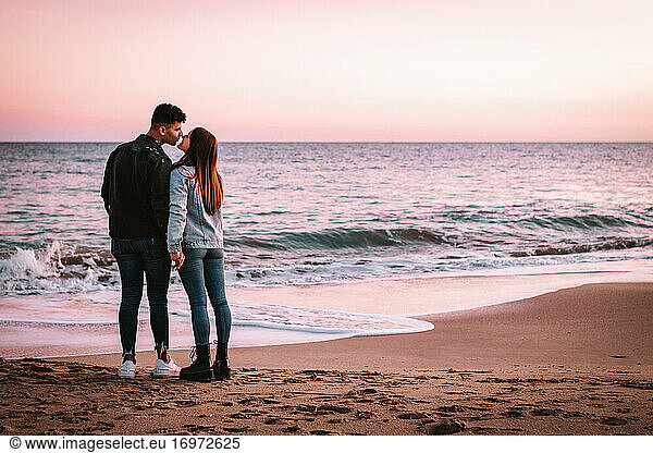 Weit Schuss eines Paares in der Liebe küssen vor dem Meer