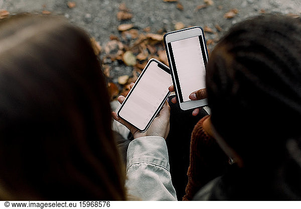Weitwinkelansicht von Teenager-Mädchen  die soziale Medien auf Smartphones nutzen