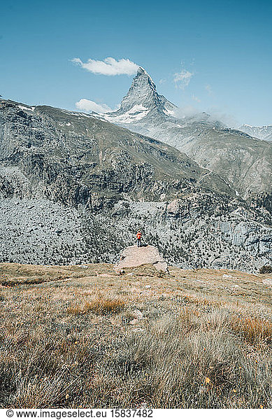 Weitwinkelaufnahme einer Frau  die vor einem Berg steht
