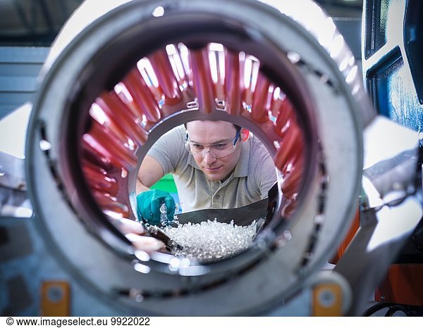 Werker inspiziert Teile von Kunststoffspritzgießmaschinen in der Kunststofffabrik