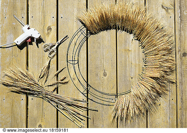 Wheat door wreath with hot glue and scissors