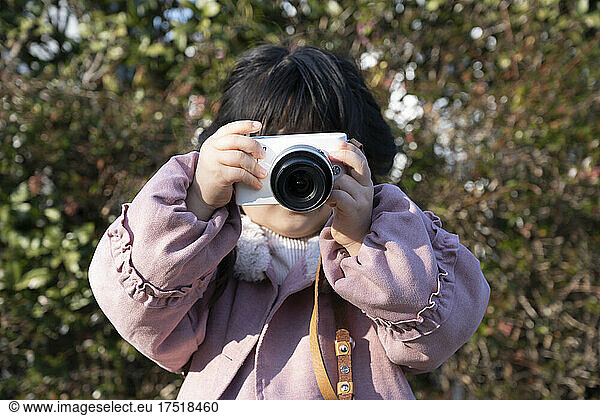 Where a little girl is holding a camera