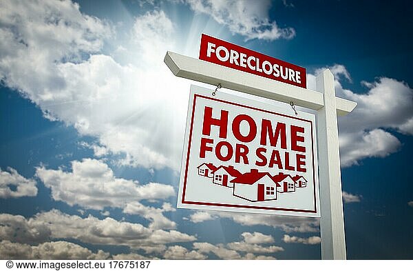 White and red foreclosure home for sale real estate sign over beautiful clouds and blue sky