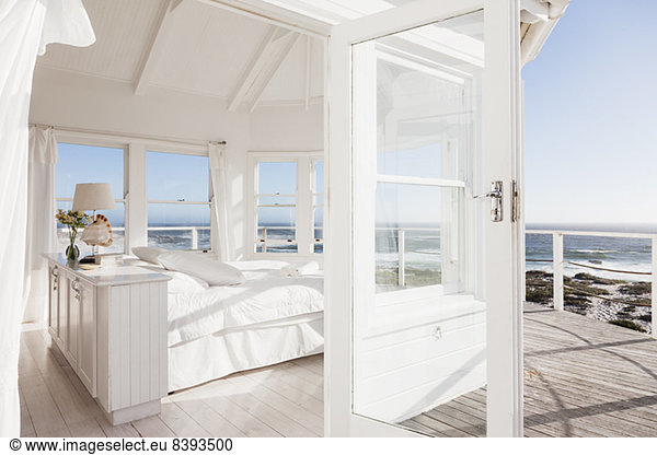 White bedroom overlooking ocean