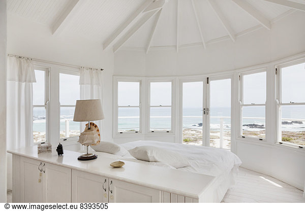 White bedroom overlooking ocean