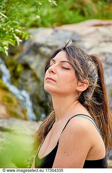 White Caucasian woman with brown hair in a ponytail  eyes closed. Concept  feeling  meditation  yoga