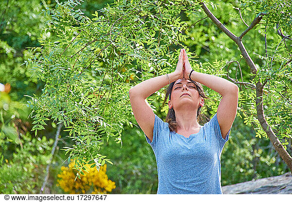 White Caucasian woman with long hair practising yoga in nature. Peace and relaxation