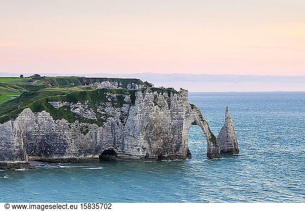White chalk cliffs and Aiguille d'Etretat  natural stone arch on the English Channel as sunset  Etretat  Seine-Maritime department  Normandy  France