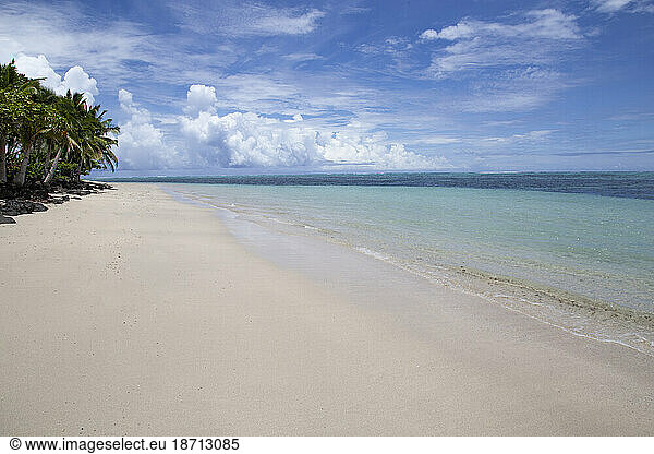White sand beach and clear blue calm waters of Samoa