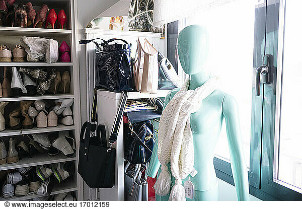 White scarf on blue female mannequin against window in wardrobe at home
