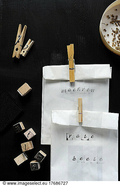 White seed bags closed with clothespins on black table