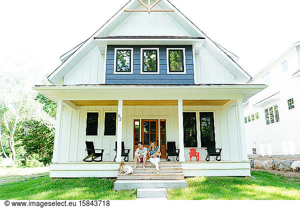 Wide view of a family together on the porch of a modern farmhouse