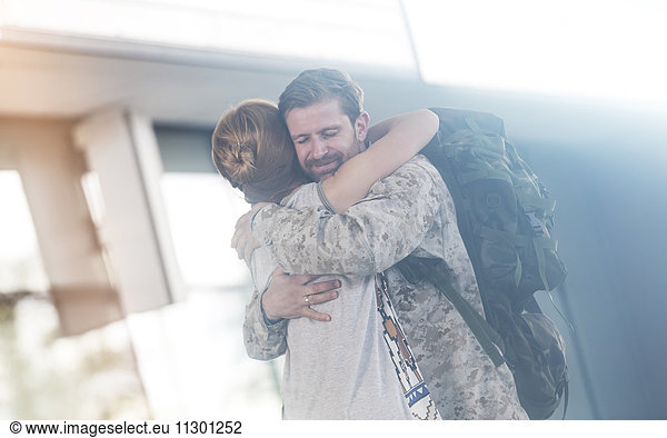 Wife greeting and hugging soldier husband at airport