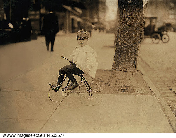 William ''Willie'' Tear  5-year-old Newsboy  Portrait Sitting on Tricycle with Newspapers  Washington DC  USA  Lewis Hine for National Child Labor Committee  April 1912