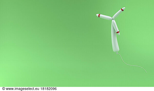 Wind turbine balloon floating against green background