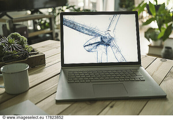 Wind turbine sketch on screen of laptop at home office