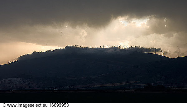 Wind turbines mixing with clouds on a mountain top