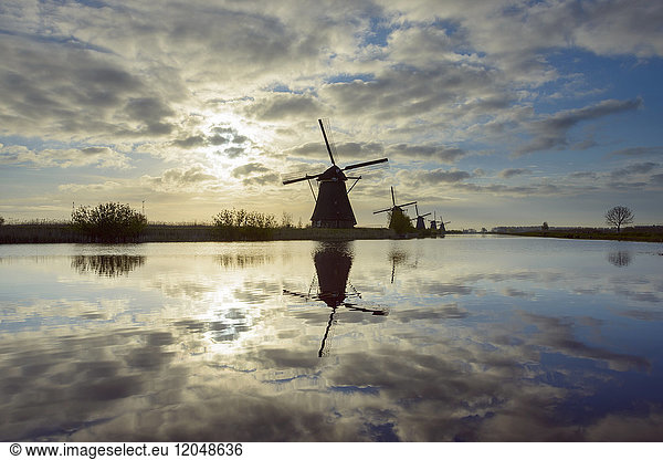 Windmühlen mit Sonne und Wolken  Kinderdijk  Südholland  Niederlande