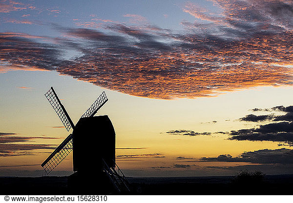Windmill at sunset under a romantic cloudy sky.