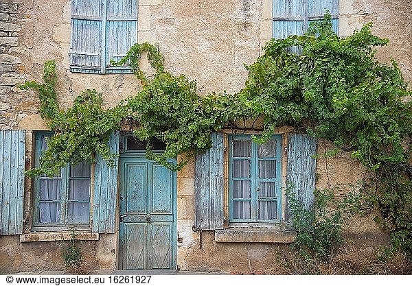 Window and door with old blue shutters in France