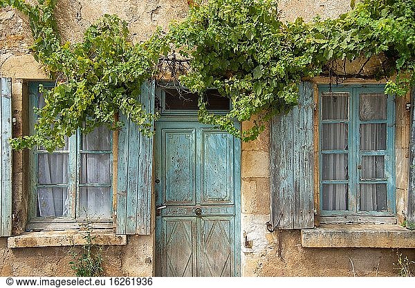 Window and door with old blue shutters in France