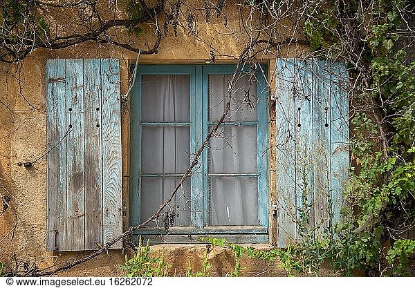 Window with old blue shutters in France