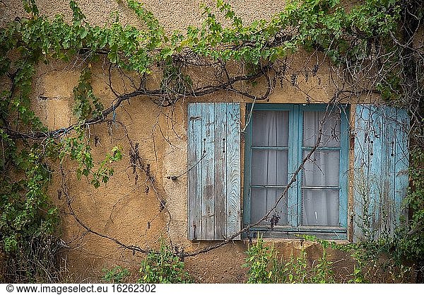 Window with old blue shutters in France
