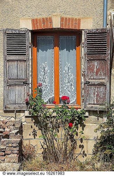 Window with old grey shutters in France