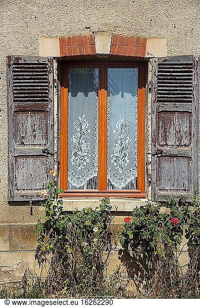 Window with old grey shutters in France
