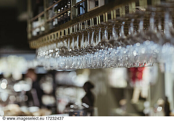 Wineglasses arranged on rack at delicatessen shop