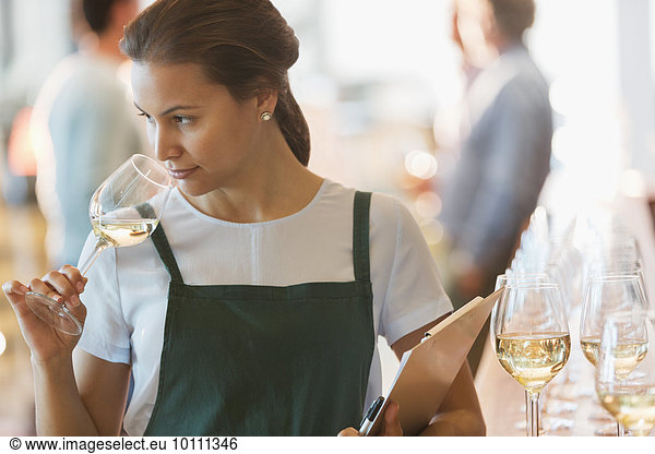 Winery employee smelling white wine in tasting room