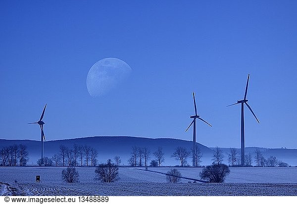 Wintery landscape and wind power plant  big moon  fog