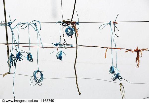 Wires with small scraps of string wound onto them. Recycling.