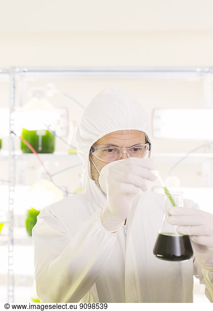 Wissenschaftler im sauberen Anzug mit Becherglas im Labor