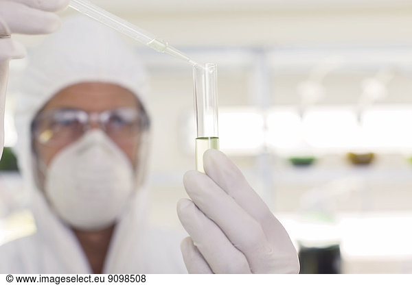 Wissenschaftler im sauberen Anzug mit Pipette und Reagenzglas im Labor
