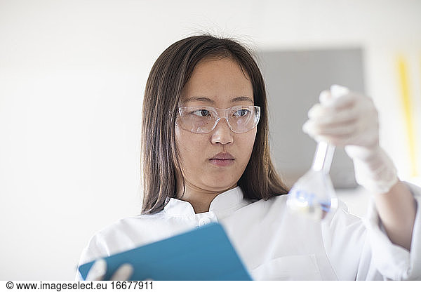 Wissenschaftlerin mit Laborbrille und Tablet in einem Labor