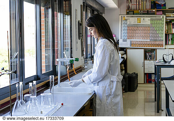 Wissenschaftlerin zieht im Labor Handschuhe aus