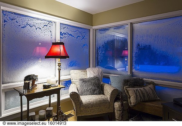 Wohnzimmersessel im Haus mit schneebedeckten Fenstern in der Nacht während eines Schneesturms. Meaford  Ontario  Kanada.