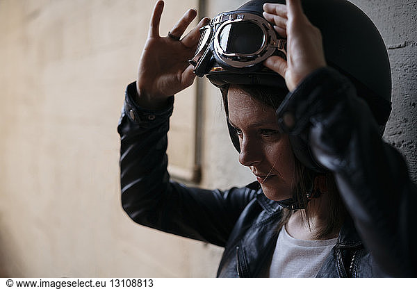 Woman adjusting flying goggles at workshop