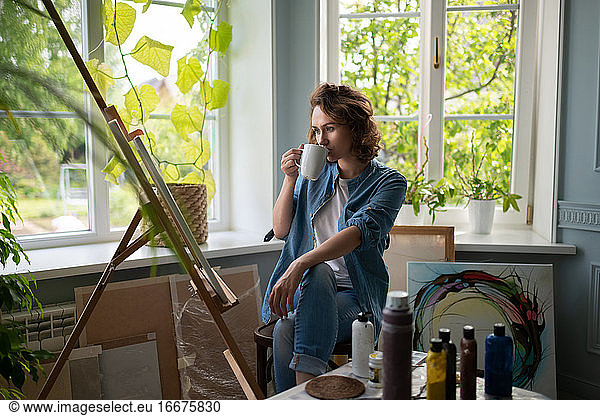Woman admiring artwork in home studio