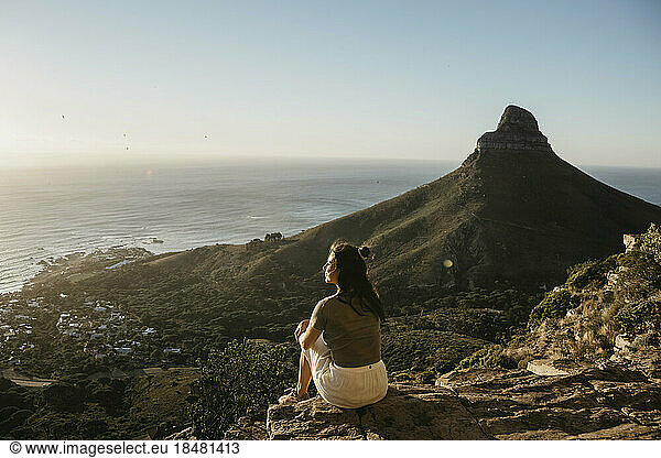 Woman admiring sea by Lion's Head Mountain at sunset