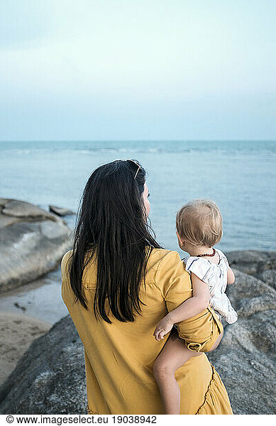Woman and baby looking out over the ocean on Koh Samui Thailand