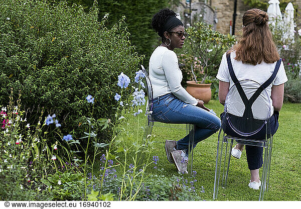 Woman and female therapist talking in a garden.